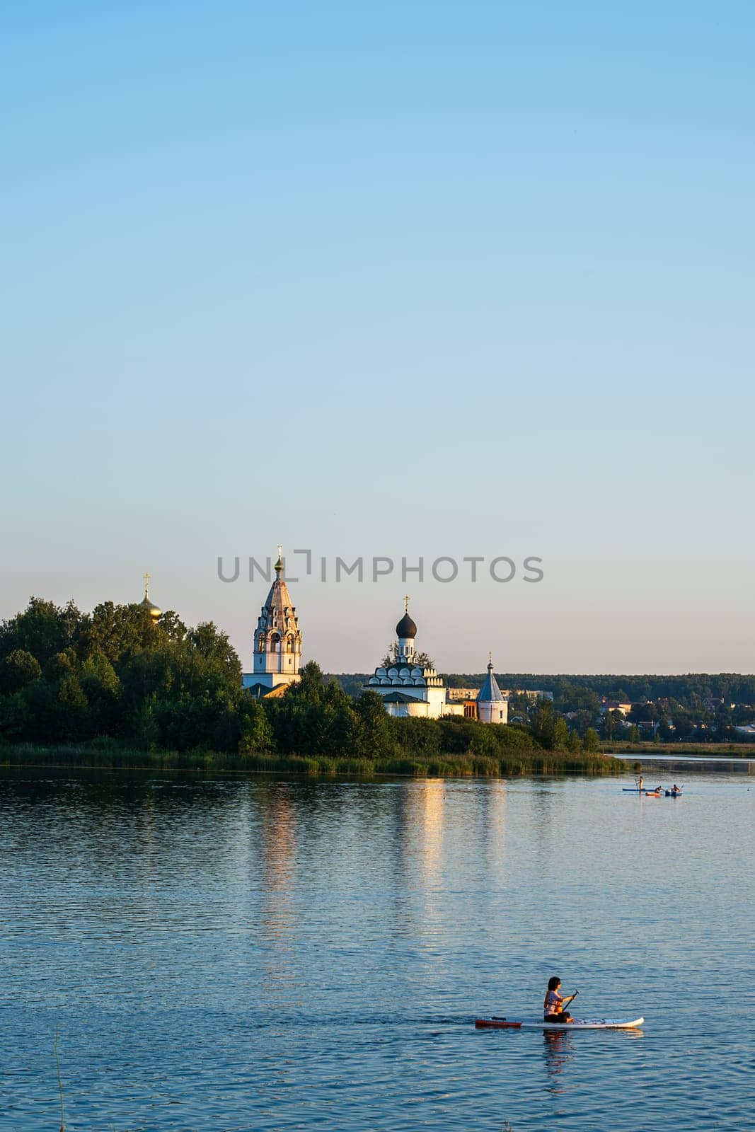 Vorsma, Nizhny Novgorod Region, Russia - 06.08.23. View of the Holy Trinity Ostrovoezersky Monastery with people on boats and SUPs.