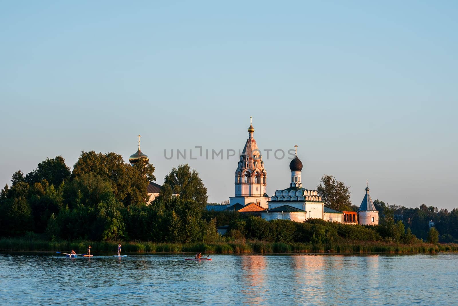 Vorsma, Nizhny Novgorod Region, Russia - 06.08.23. View of the Holy Trinity Ostrovoezersky Monastery with people on boats and SUPs.