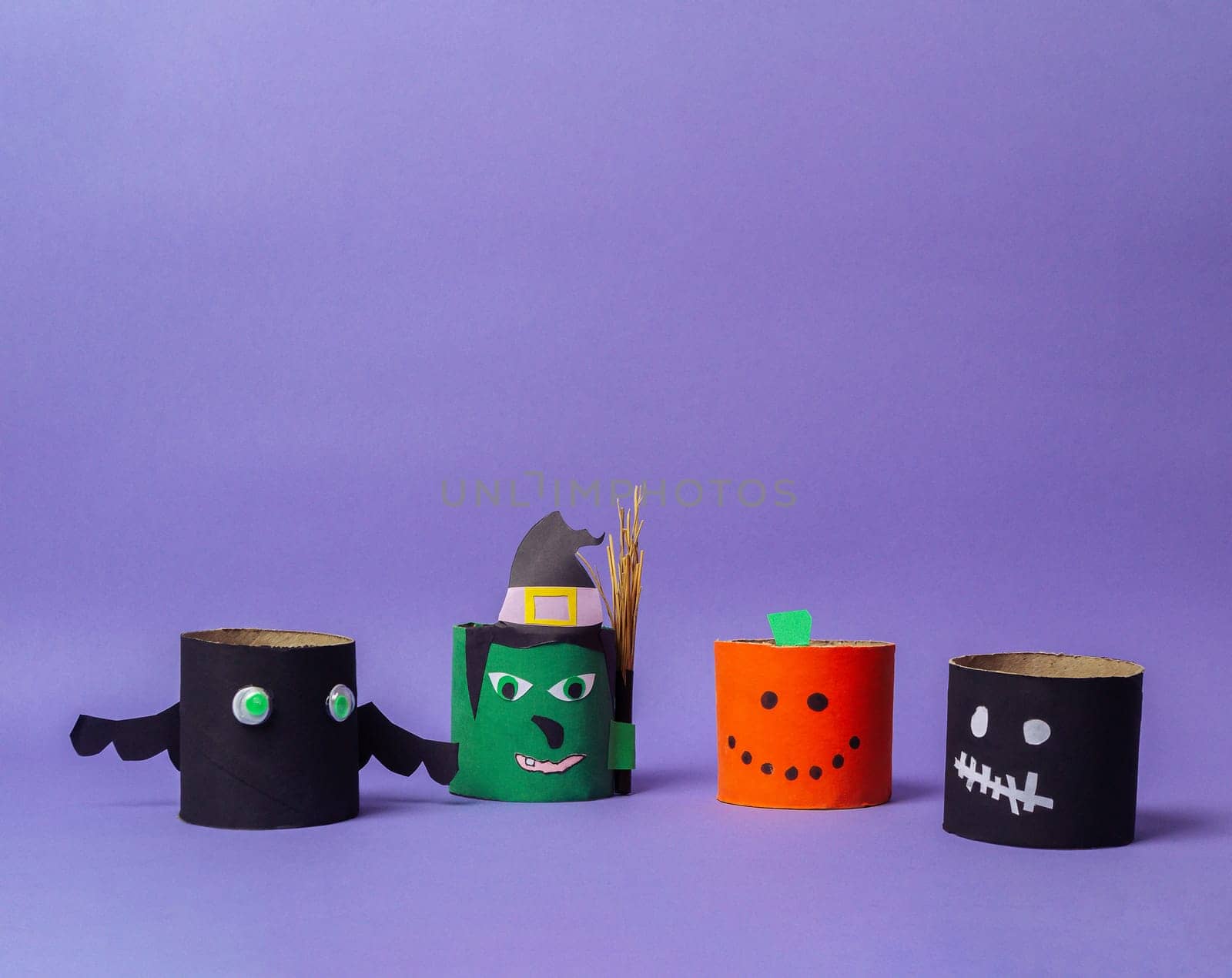 Group of Halloween decorations made from paper tubes. One of the tubes has a pumpkin on it