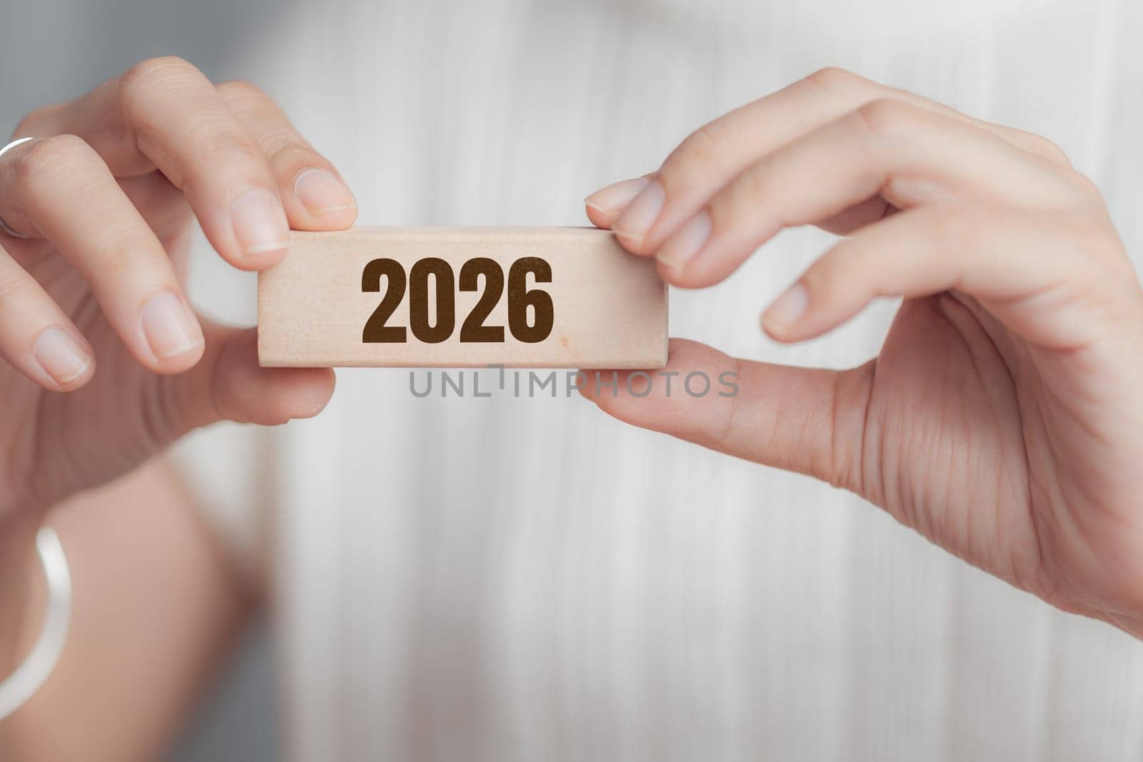 Female hand holding wooden block with 2026. Concept of new year, future planning, goals, resolution, timeline, and personal or business growth.