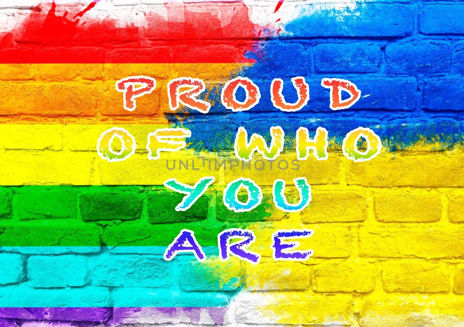 Colorful sign that says Proud of who you are. The sign is on a brick wall