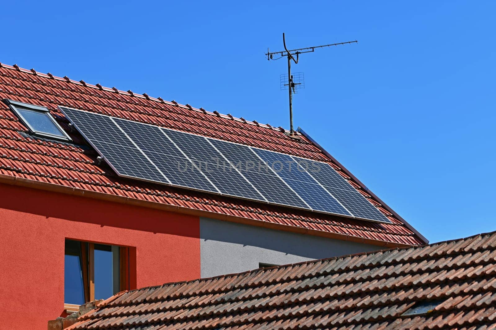 Family house with solar panels on the roof. Home photovoltaic power plant. Concept for industry and green cheaper electricity from renewable sources.