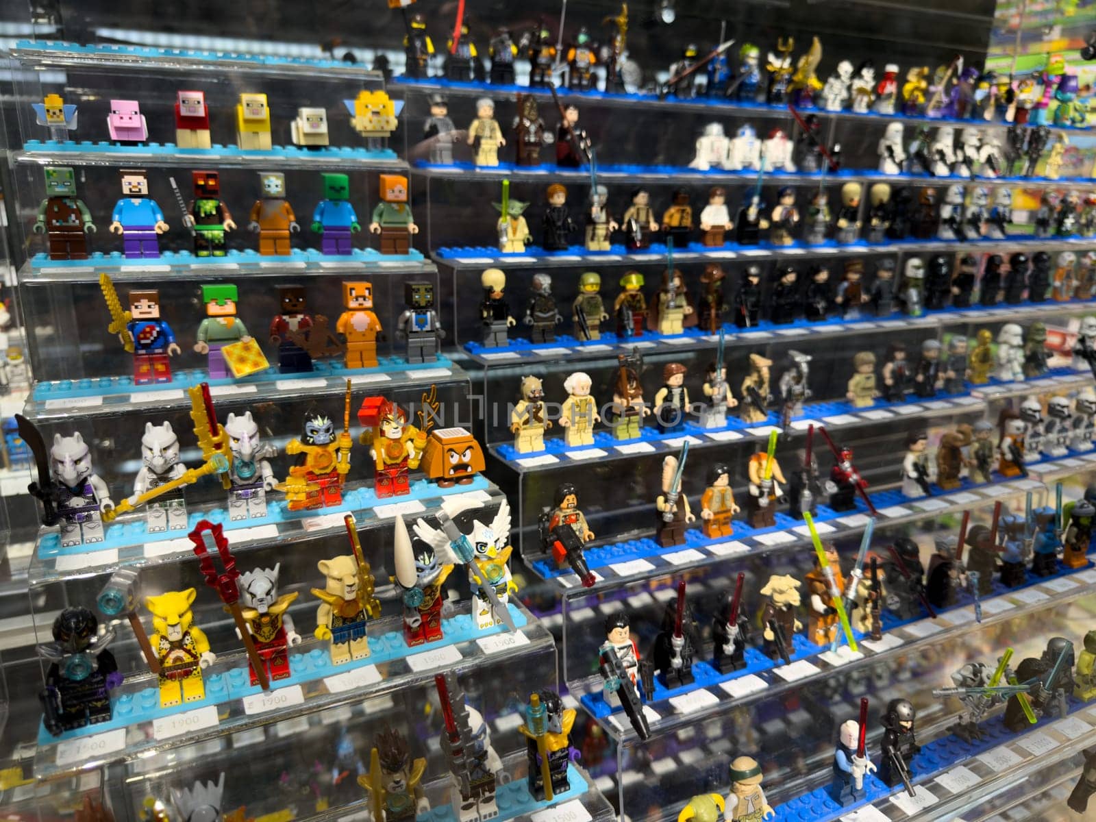 Moscow, Russia, April 25, 2025: Large variety of themed Lego minifigures on display inside Lego museum and retail corner, including characters from Minecraft, Star Wars and other popular franchises