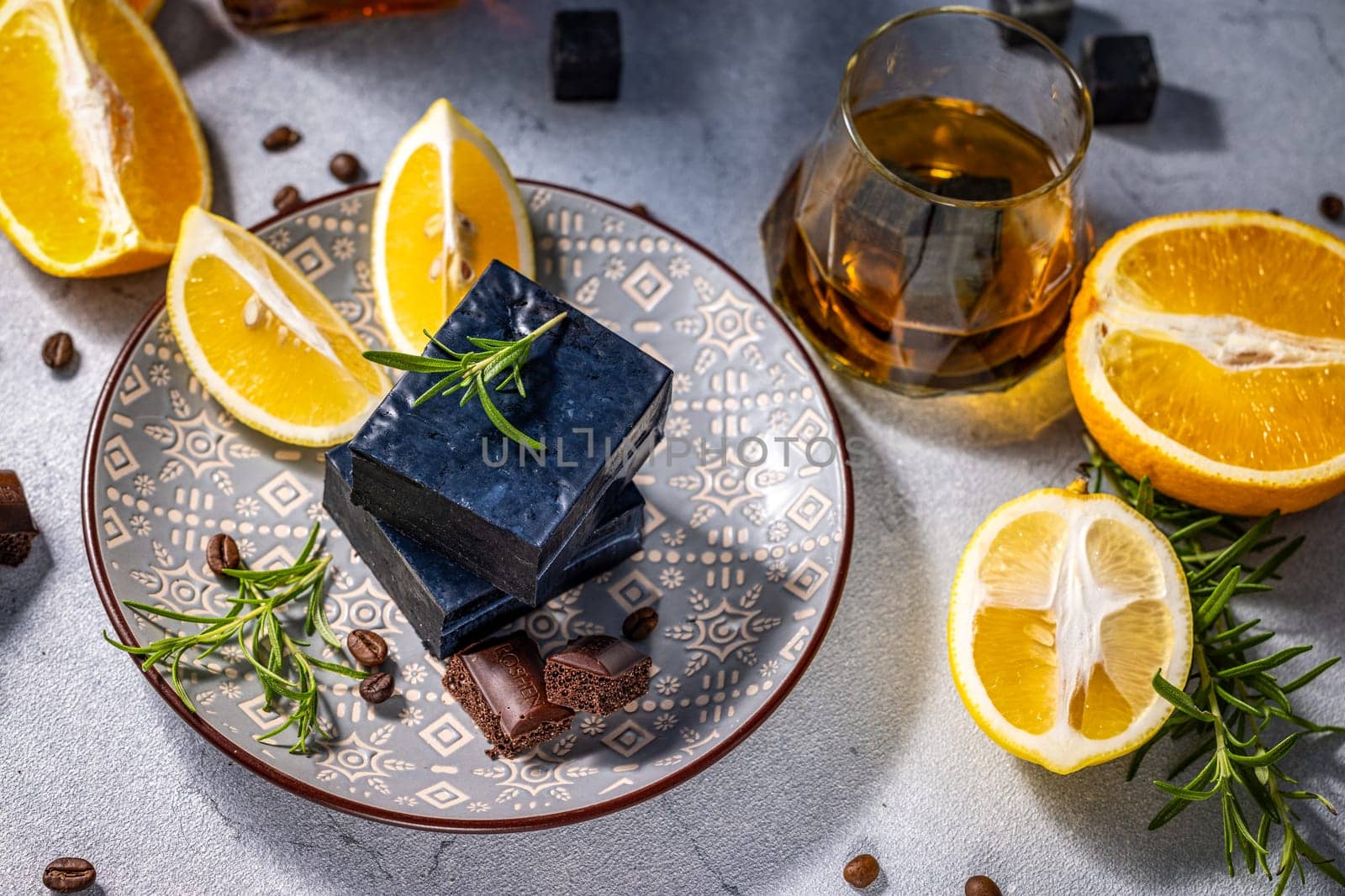 Composition of Gourmet black cheese served with lemon, rosemary, coffee beans, aerated chocolate and glass of whisky