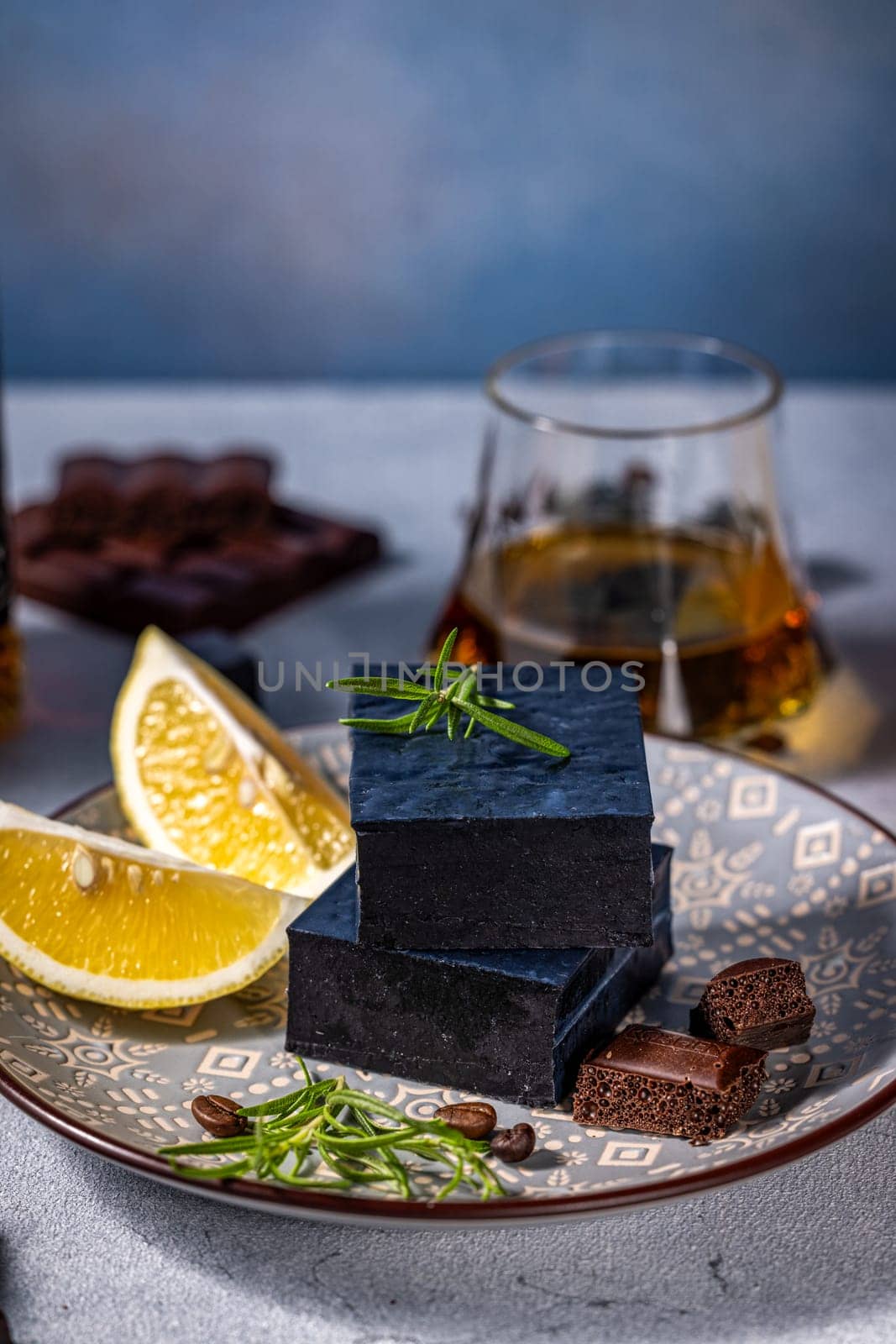 Gourmet black cheese served with lemon, rosemary, coffee beans, aerated chocolate and glass of whisky
