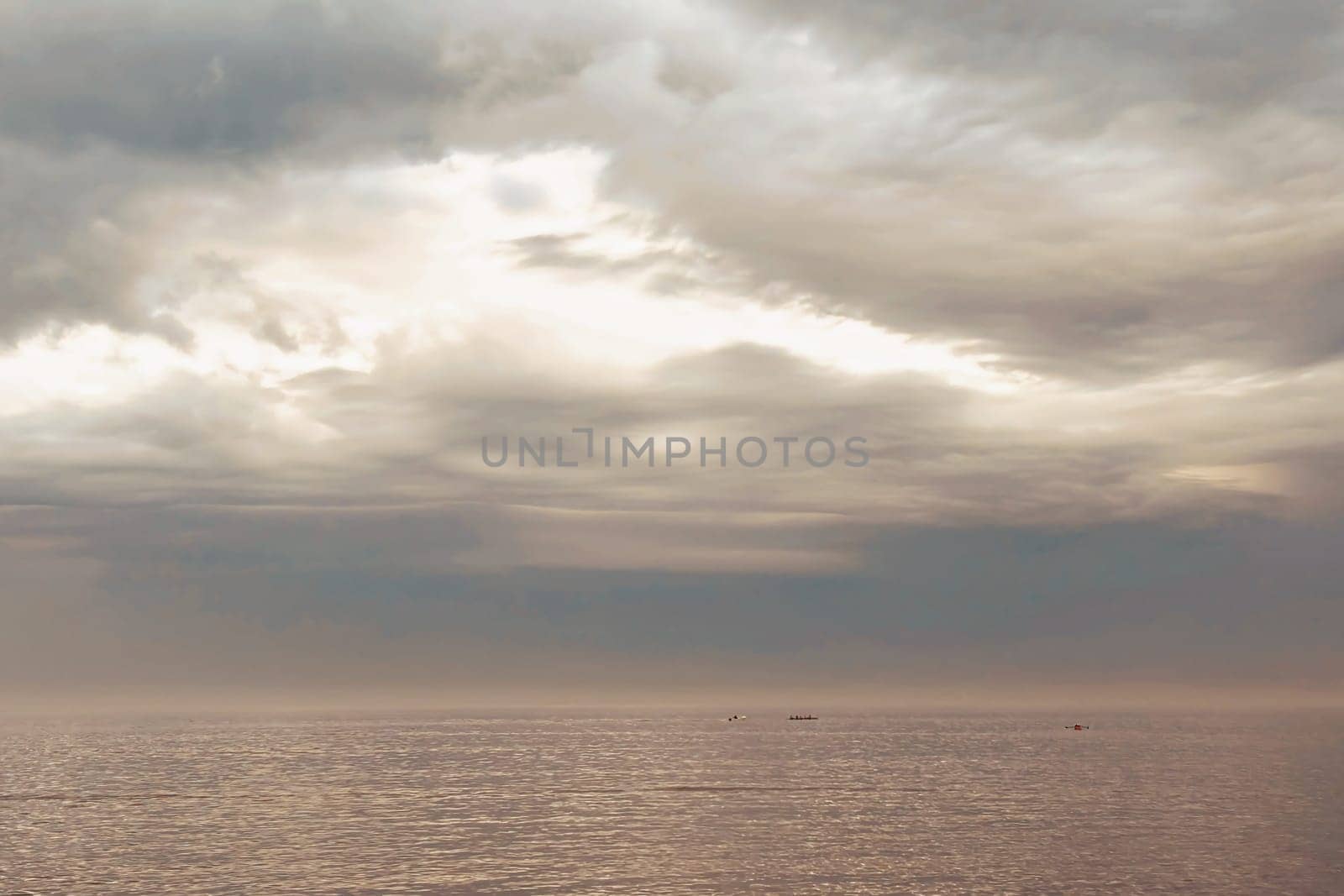 Sunrise and dramatic clouds. Early morning serene seascape in spring. Serene Spring Dawn.Witness the tranquil beauty of an early spring morning. The sun rises, casting a warm glow upon a calm sea, while dramatic clouds paint the sky, creating a breathtaking and serene seascape.
