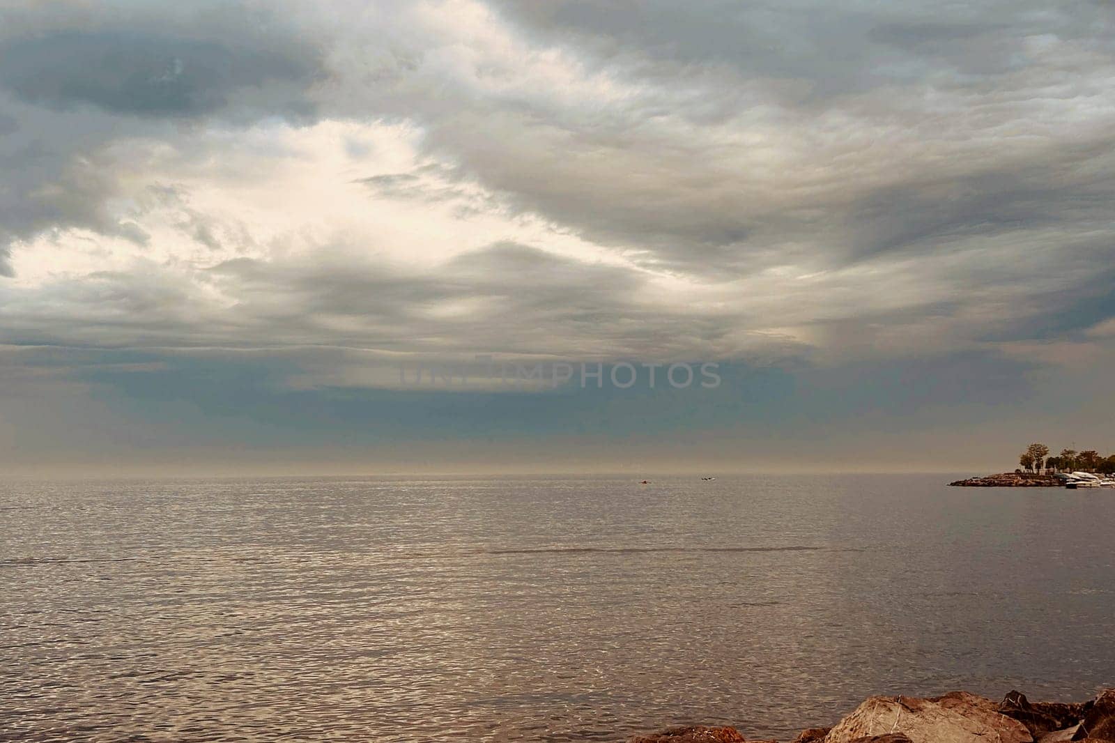 Sunrise and dramatic clouds. Early morning serene seascape in spring. Serene Spring Dawn.Witness the tranquil beauty of an early spring morning. The sun rises, casting a warm glow upon a calm sea, while dramatic clouds paint the sky, creating a breathtaking and serene seascape.