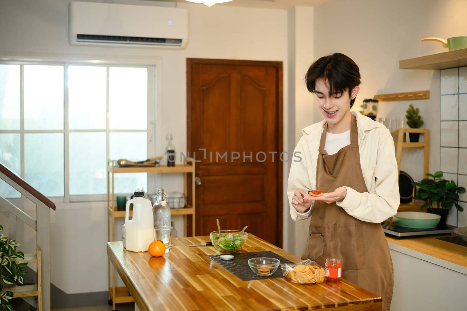 Young man enjoying homemade snack in cozy kitchen.
