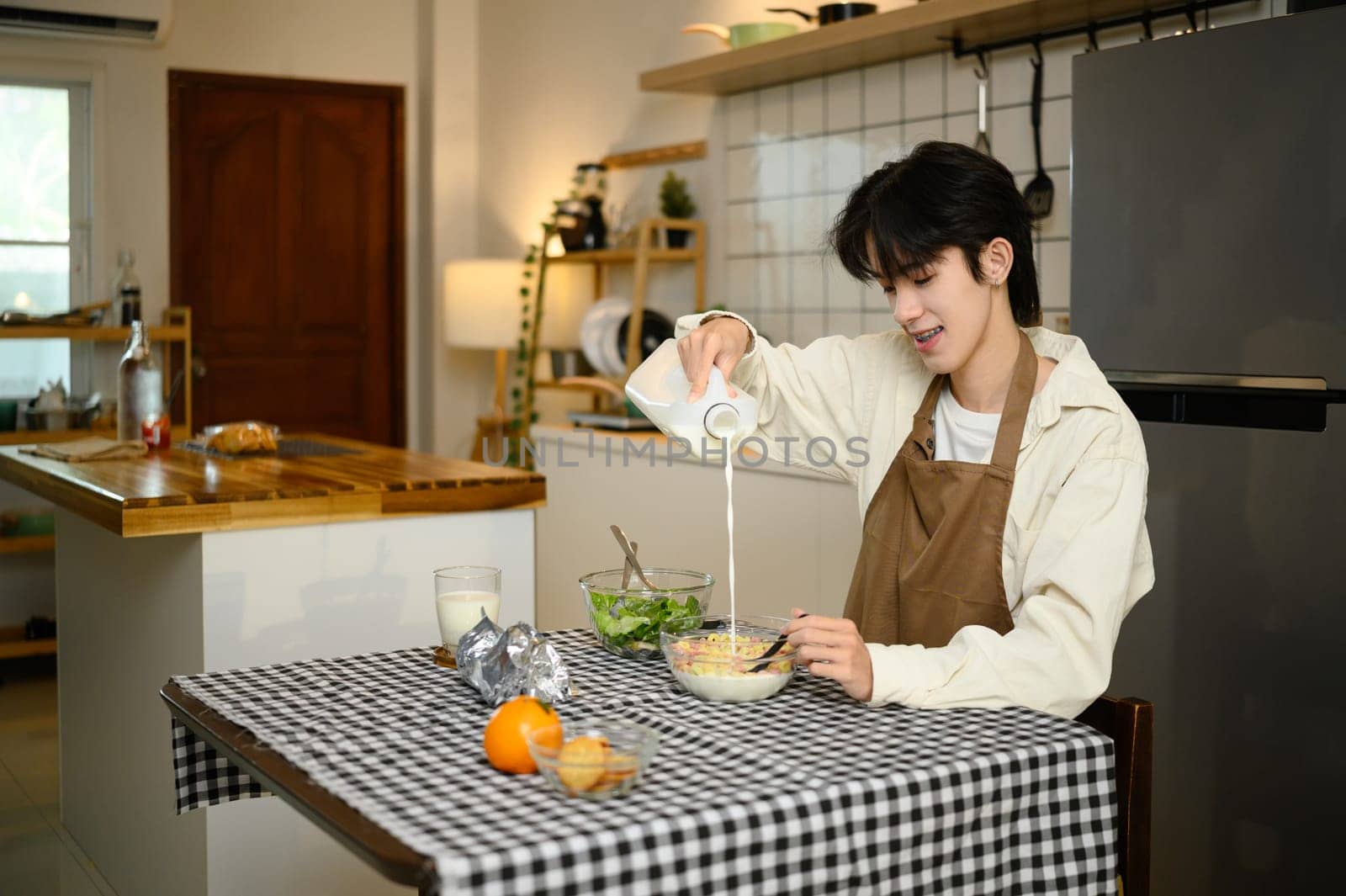 Young asian man enjoying healthy breakfast at home.