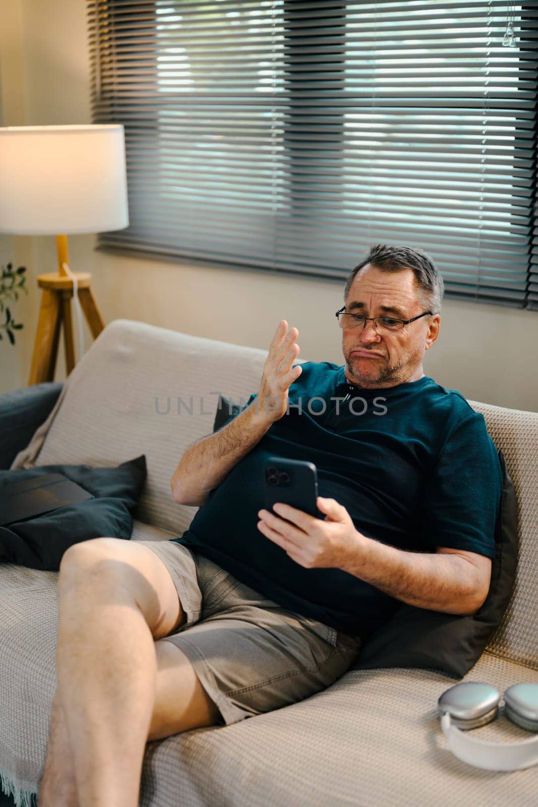 Elderly man having video call or checking messages on his smartphone.