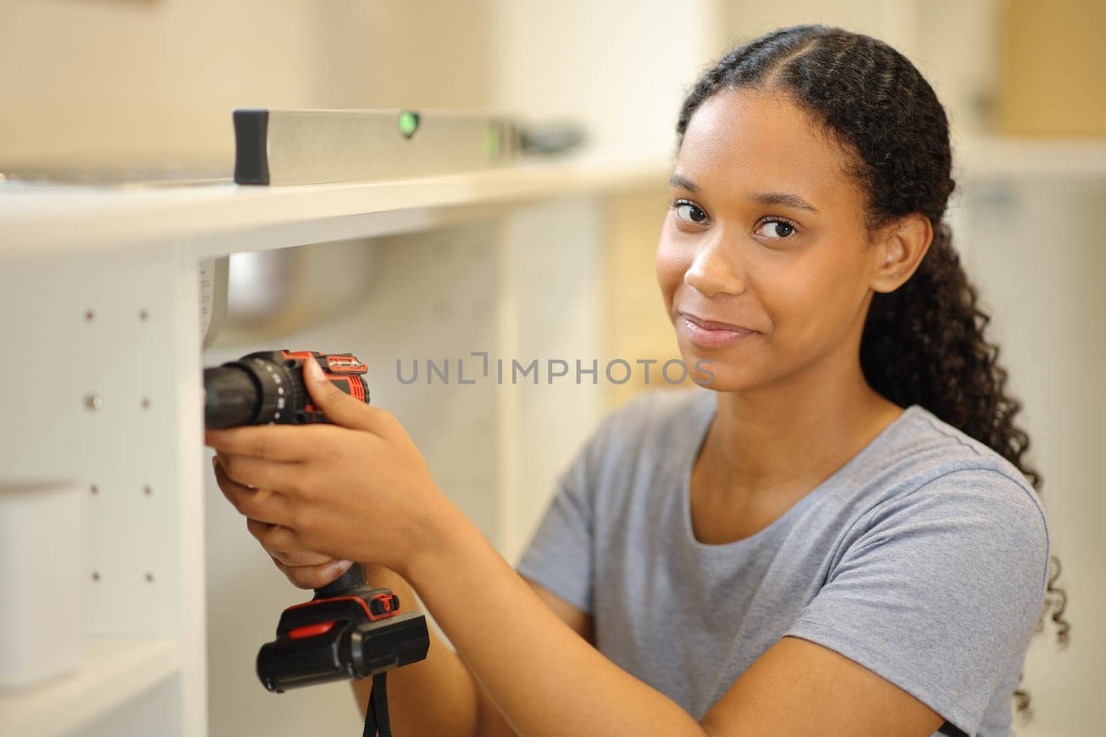 Portrait of a black woman reforming house looks at camera in the kitchen