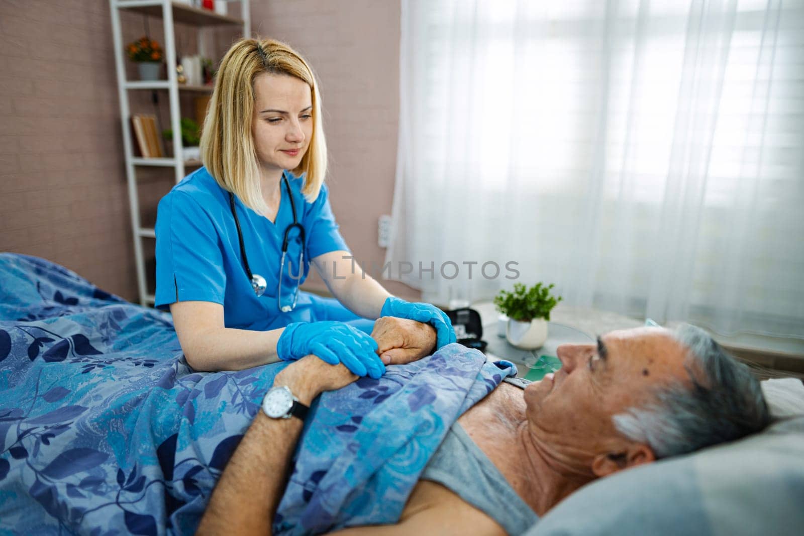 Gentle nurse comforts senior man in a cozy healthcare setting.