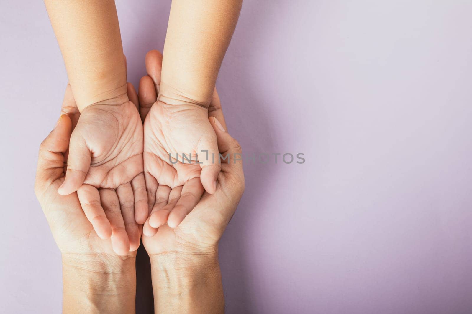 Family day concept, Top view of parents and kid holding empty hands together on a color background. Celebrating togetherness.