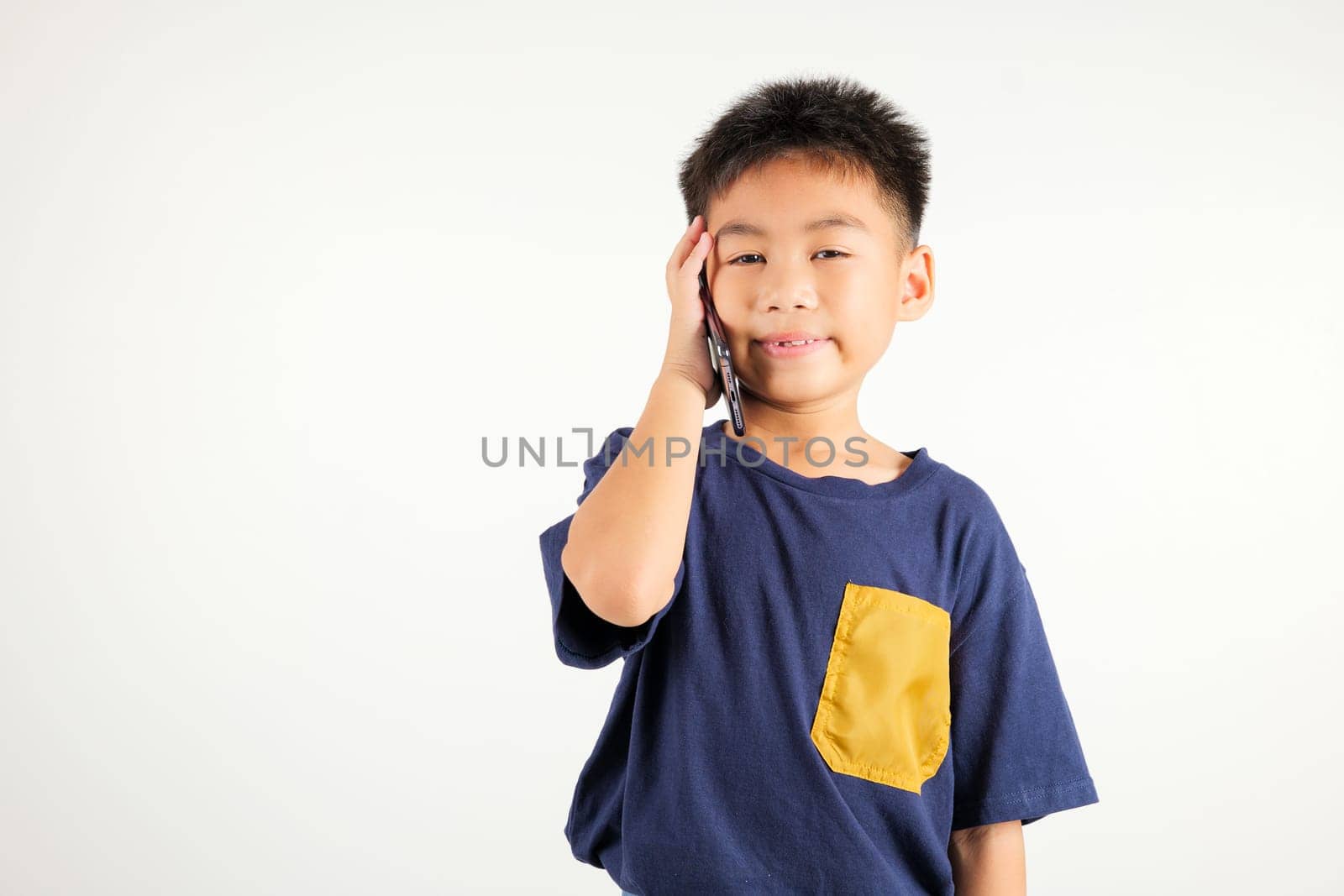 Happy Asian portrait cute young kid boy smiling excited talking smart mobile phone studio shot isolated on white background, Thai child calling gesture on smartphone