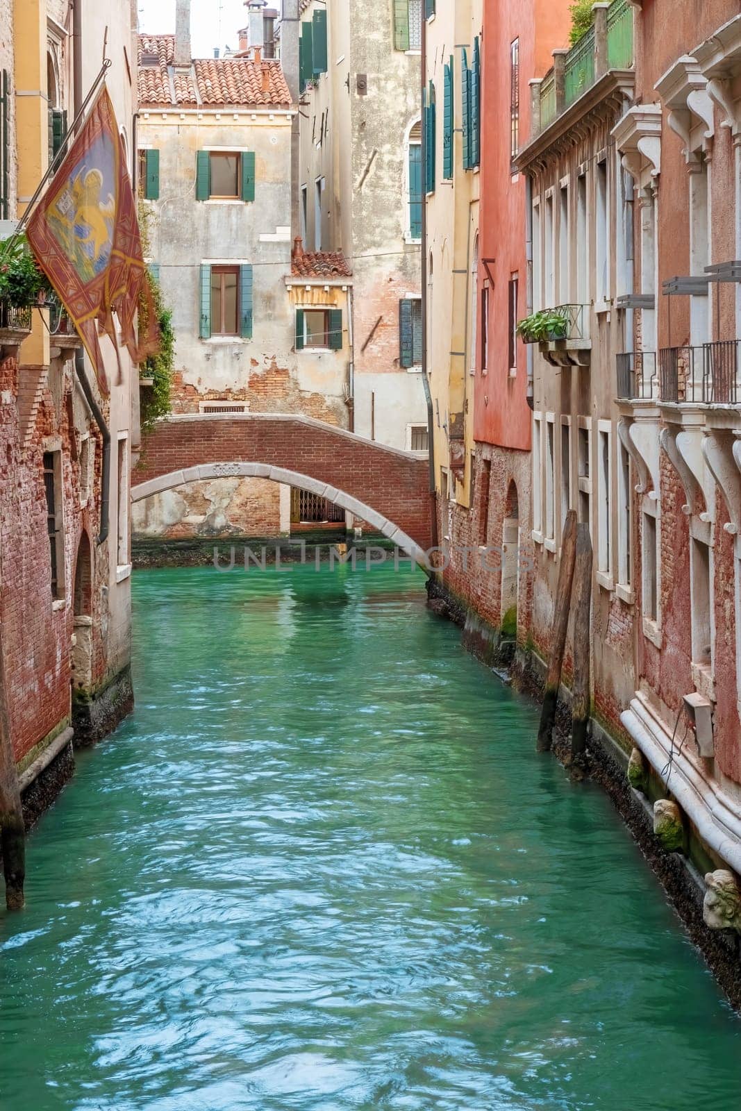 Colorful photo of quiet canal in Venice. Italy. Vertically. 