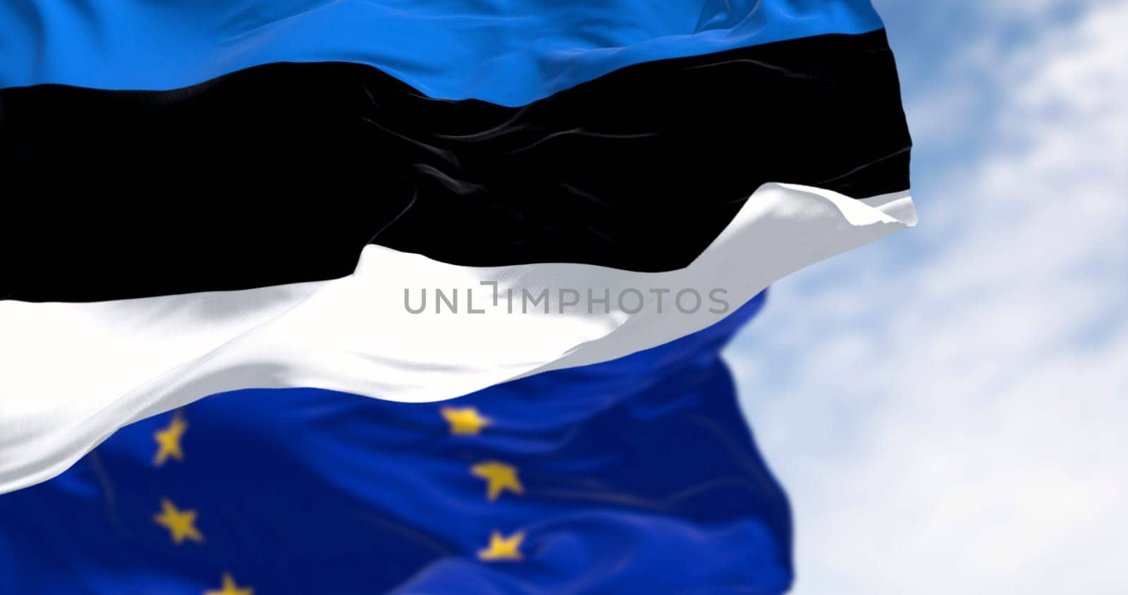 The flags of Estonia and the European Union waving together on a clear day. Estonia became a member of the European Union on May 1, 2004. Realistic 3d illustration. International treaty and diplomacy