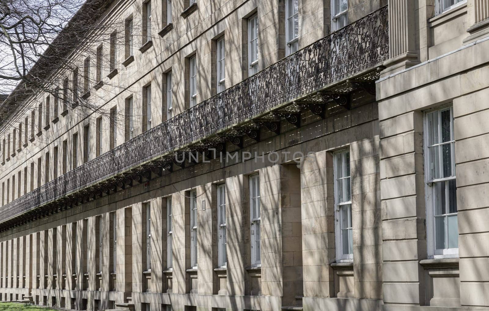 Newcastle, UK - Apr 13, 2025 - Perspective view of Leazes Terrace is an elongated square of houses with Wrought iron black railings balconies and Glass windows in Newcasle, is a Grade I Listed Building which encloses a courtyard in the centre of the City Of Newcastle. Georgian houses and trees in Newcastle-upon-Tyne, use it as your Wallpaper, Poster and Space for text, Selective focus.