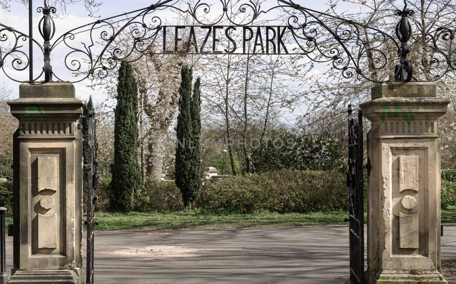 Newcastle, UK - Apr 13, 2025 - View of Cast iron lamp over the Wrought iron gate is open to the entrance of Leazes park with beautiful sky background. use it as your Wallpaper, Poster and Space for text, Selective focus.