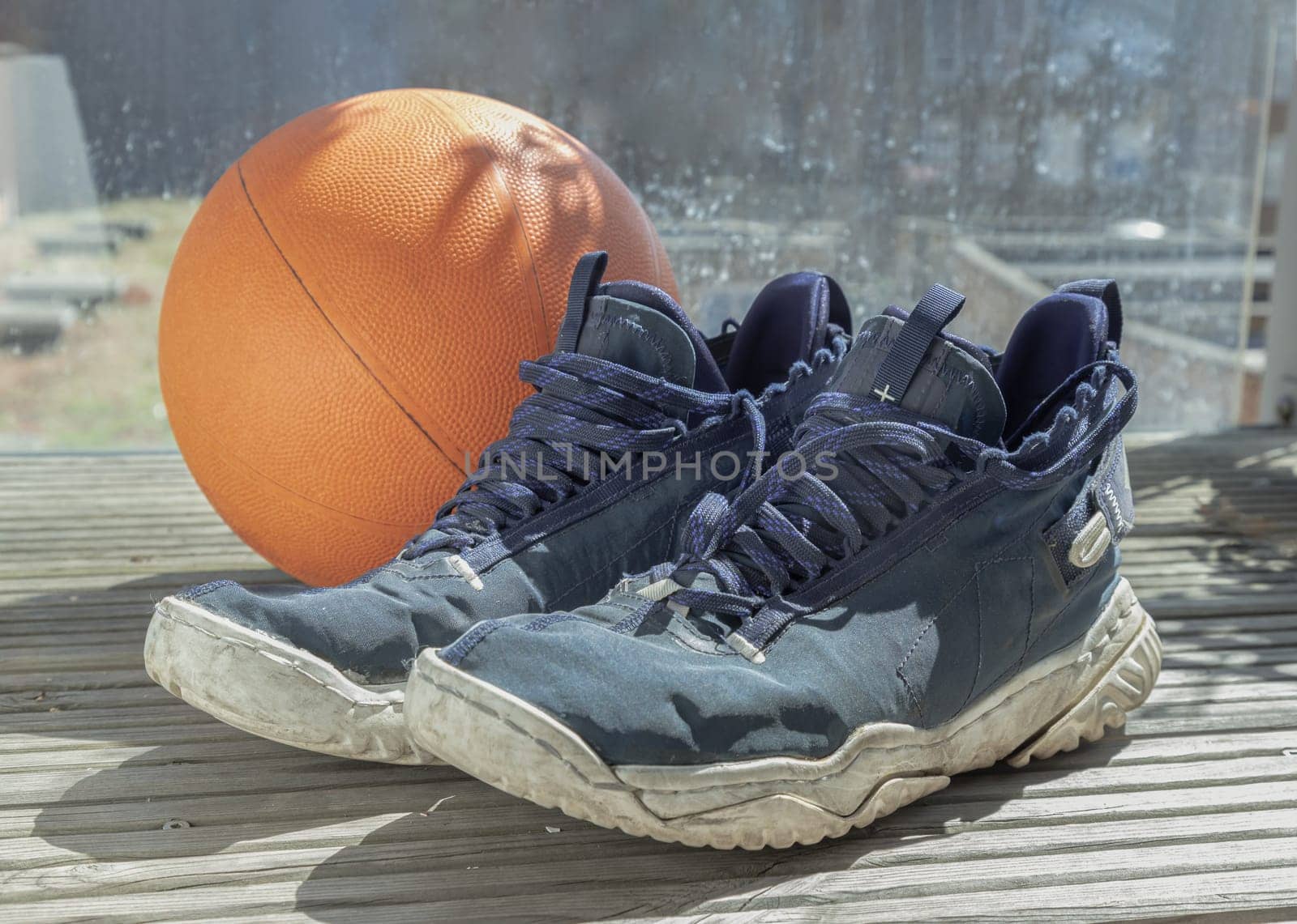 London, UK - May 17, 2025 - Basketball shoes and basketball ball are placed on the balcony, after training from playing basketball. use it as your Wallpaper, Poster and Space for text, Selective focus.