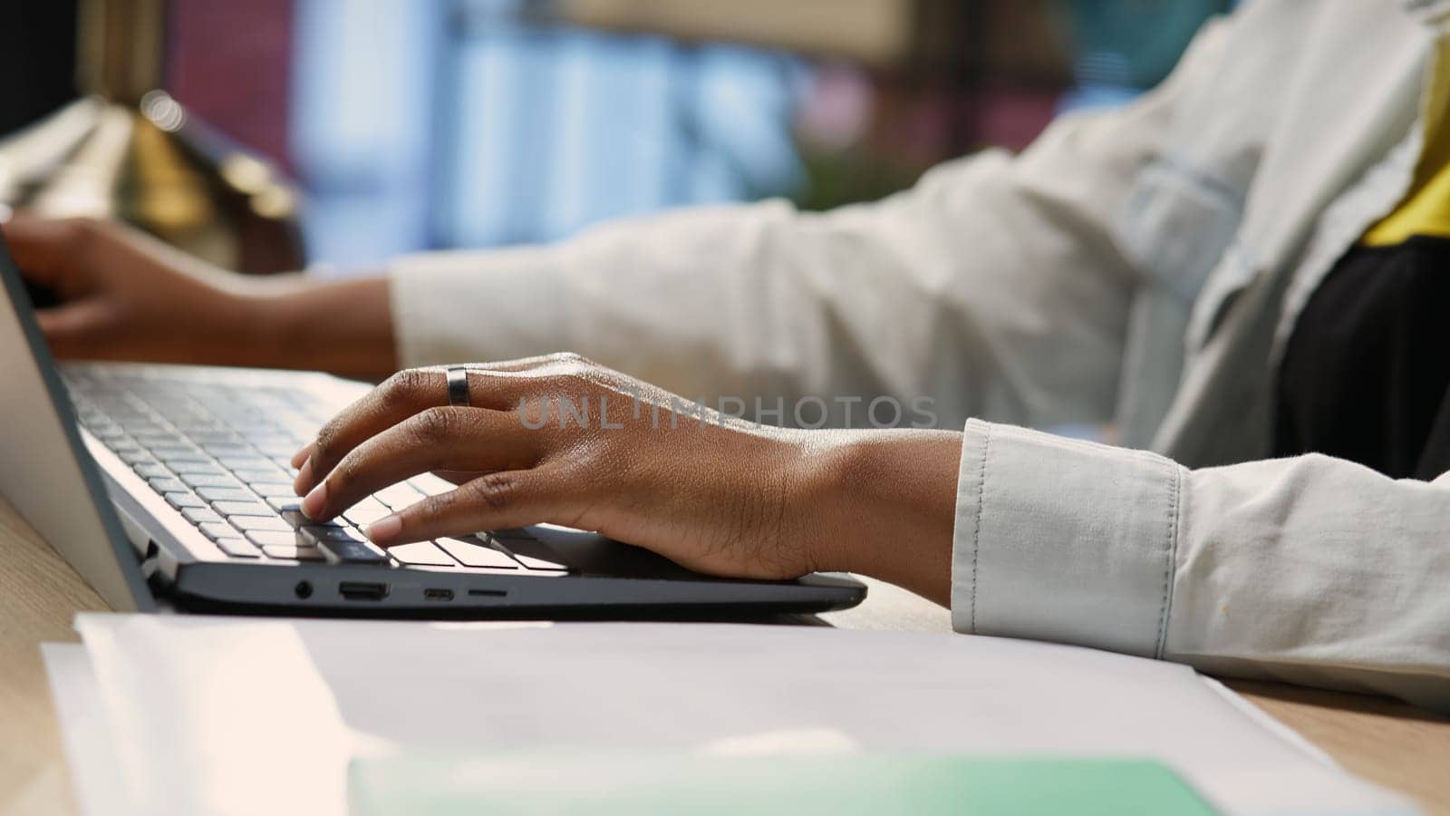Freelancer in home office sitting at desk and typing on laptop keyboard. Close up of remote worker using electronic device to do customers relations job online, answering inquiries, camera B