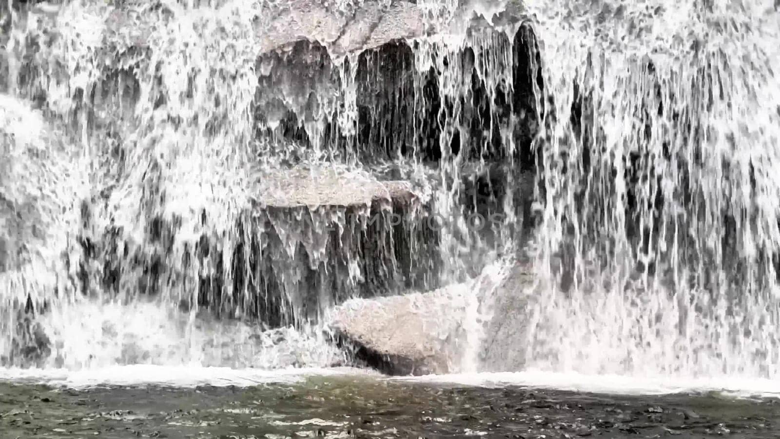 A serene and tranquil view of cascading water flowing gracefully over rocks, capturing the pure beauty of natures flow