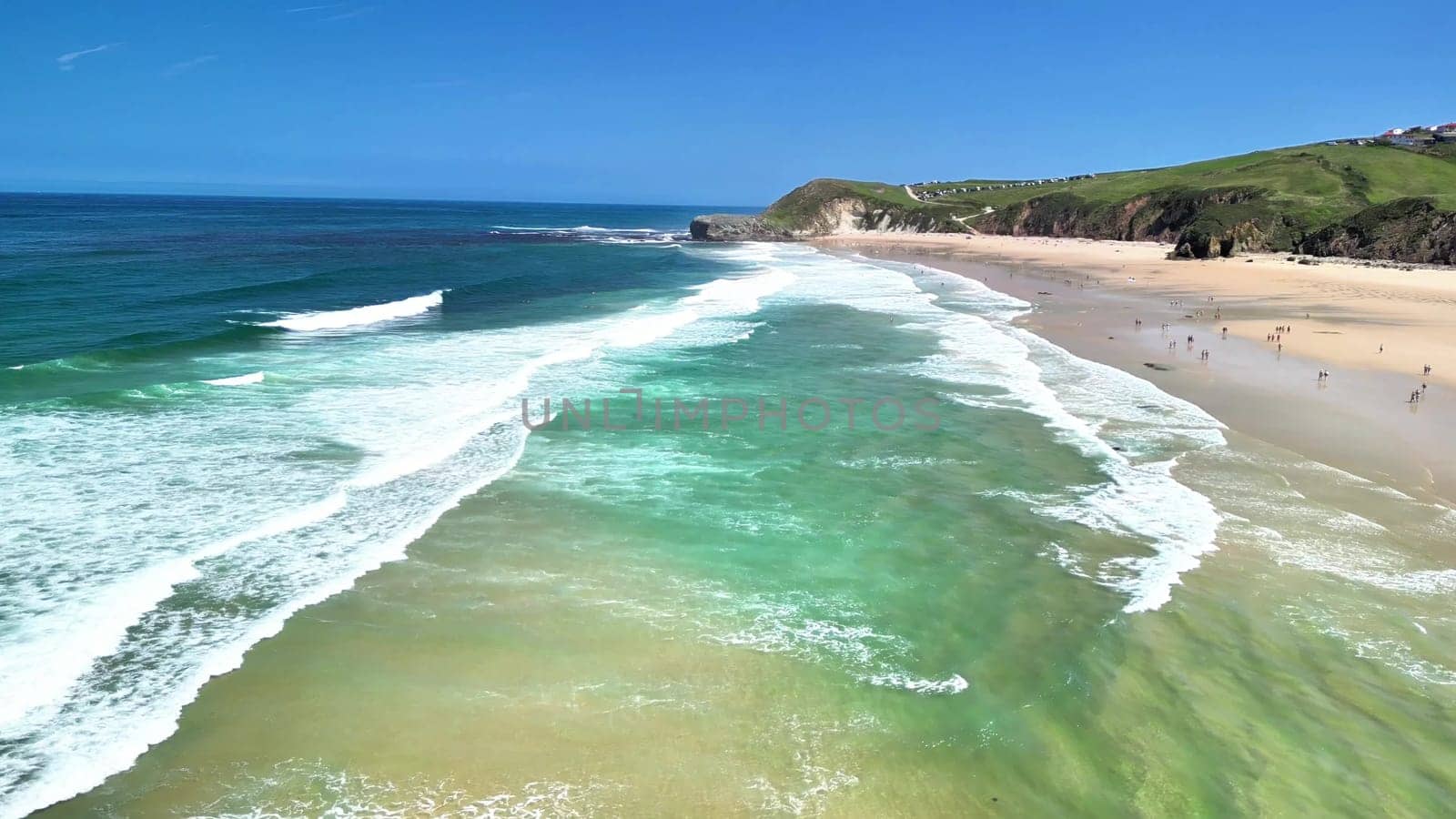 Stunning aerial shot showcasing a picturesque beach with clear turquoise water and vibrant greenery.