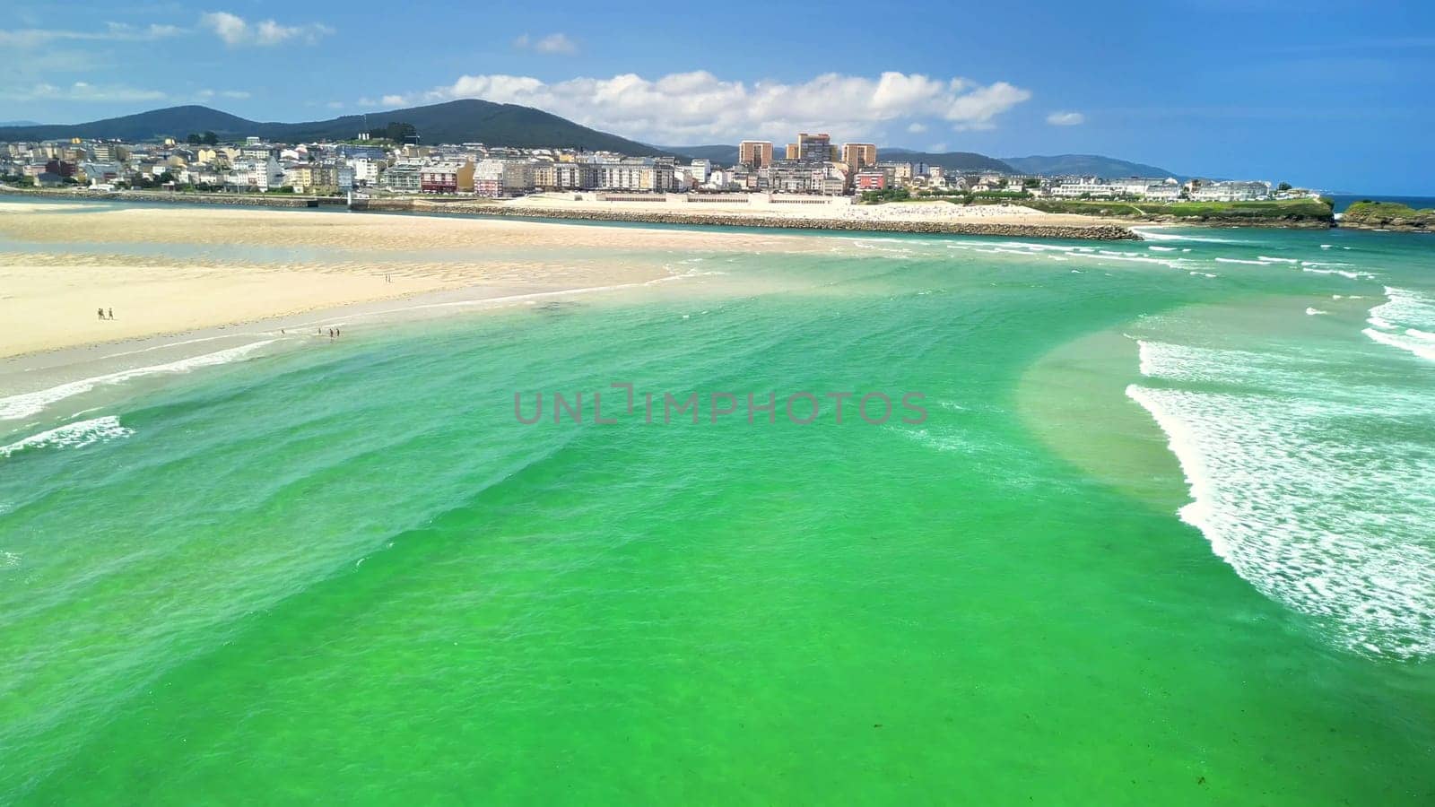 A stunning aerial shot beautifully showcasing the turquoise waters meeting the picturesque sandy shoreline