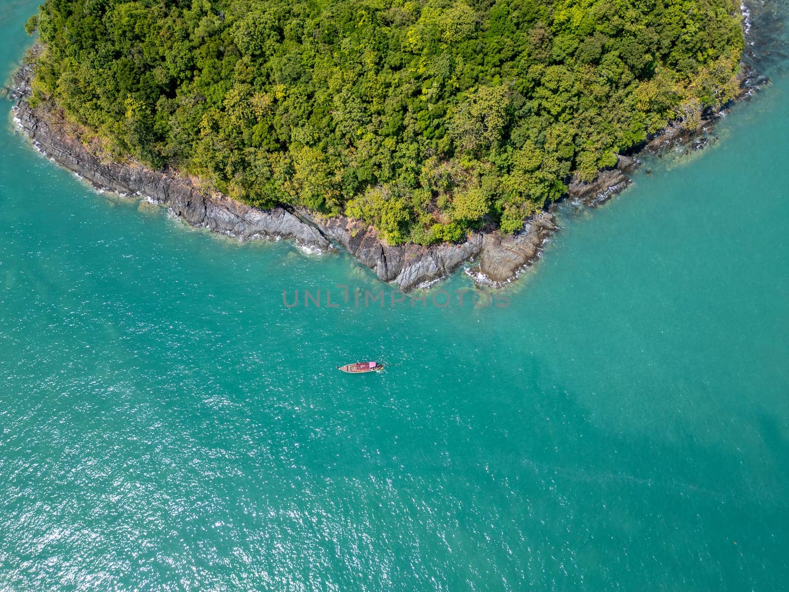 Aerial view of tropical bay with boats and a stunning blue seascape, beautiful blue open waters showing sailboats floating on calm waves in a Thai lagoon. Bright blue sky, summer getaway.