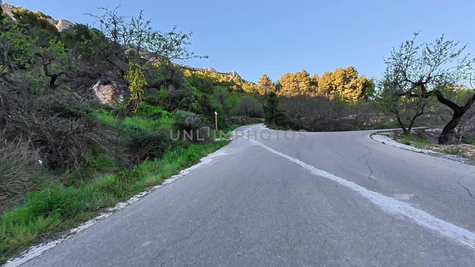 A breathtaking and picturesque view of a winding road, beautifully surrounded by lush greenery and scenic hills