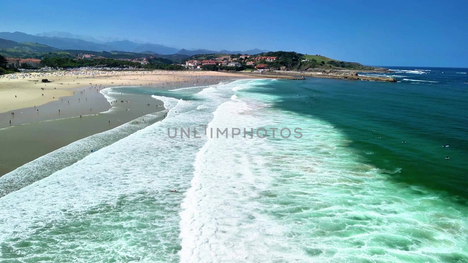 A breathtaking and stunning aerial view showcasing a vibrant, beautiful beach with inviting waves and clear, blue skies