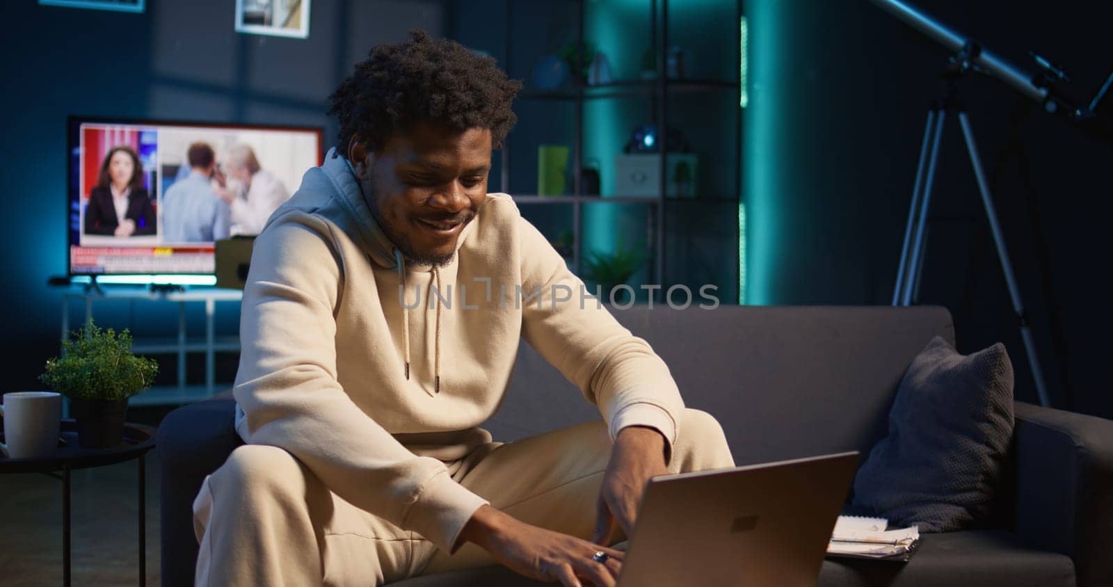 African american male freelancer managing creative projects remotely in his loft, working on a new novel or script for his gig. Man focusing on writing and editing creation, telework. Camera B.