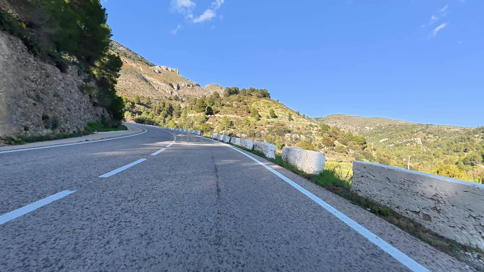 The view of the winding mountain road is absolutely breathtaking, beautifully surrounded by lush greenery all around