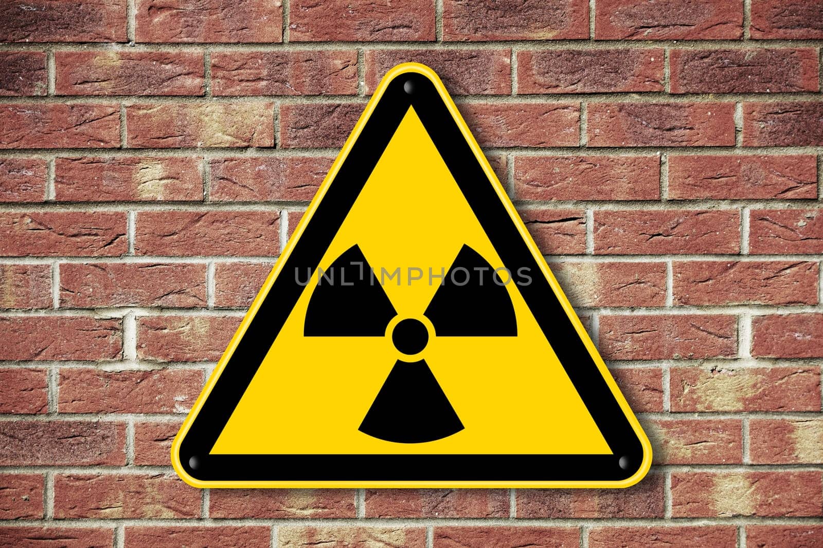 A radioactive caution warning sign on a brick wall background