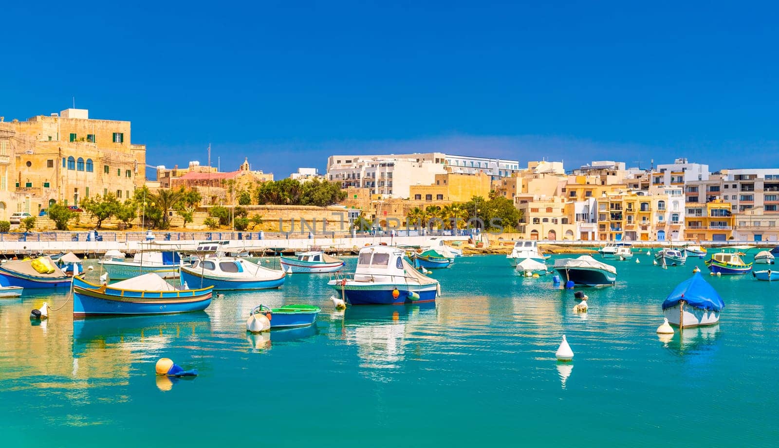 Beautiful cityscape of Birzebbuga with fishing boats lying on the water, Malta.