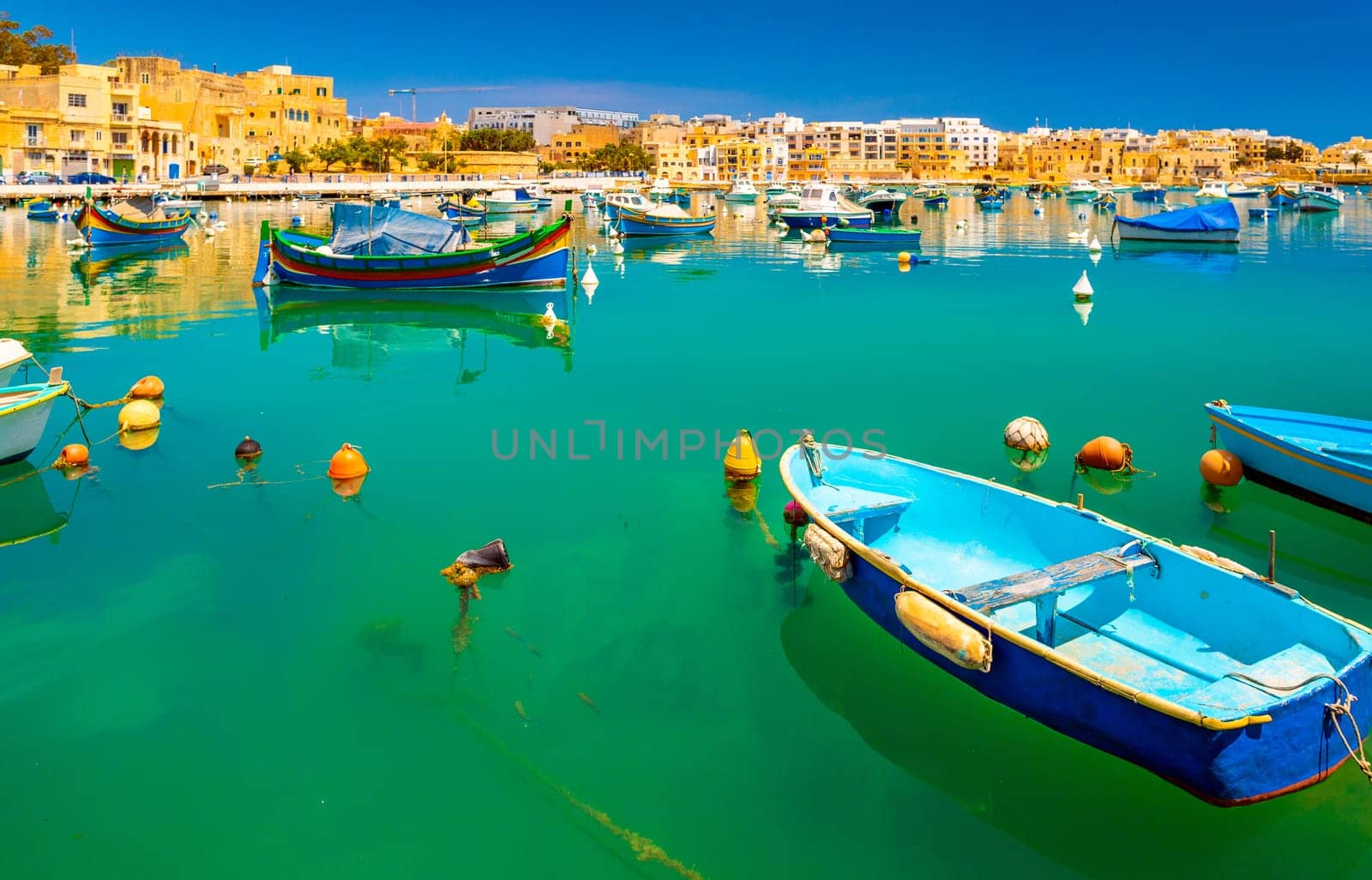 View of the small town of Birzebbuga with fishing boats lying on the water, Malta.
