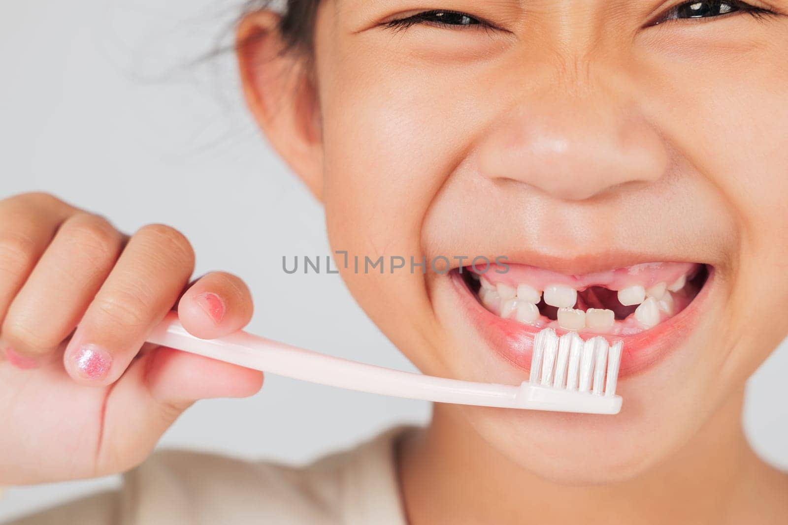 Cheerful kid brushes teeth, revealing a tooth gap. The dentist shares tips on tooth loss and caring for a tooth gap to ensure strong teeth growth. isolated white background