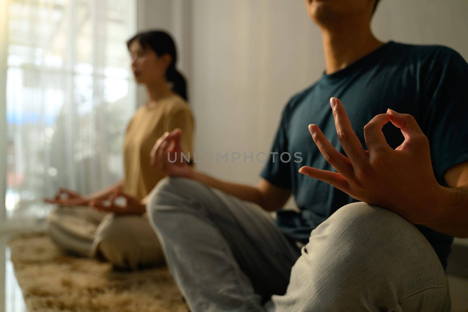 Young couple practicing meditation in a calm home.