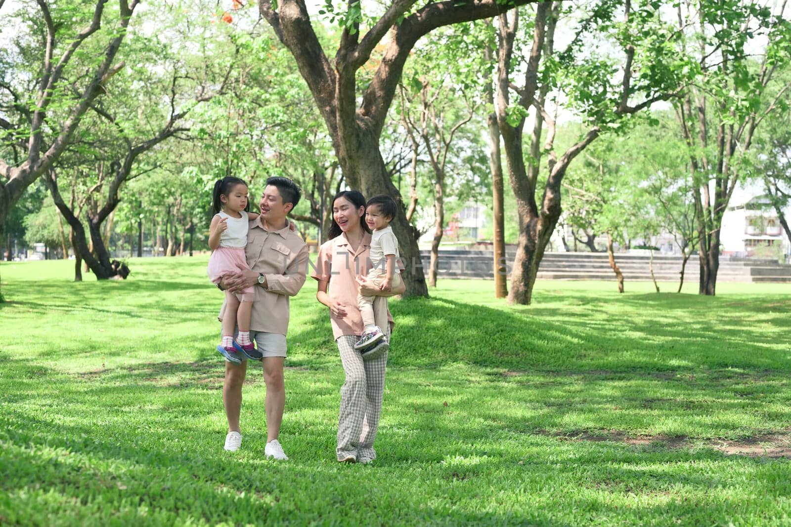 Happy family walking in the park on a sunny day, enjoying quality time and fresh air.