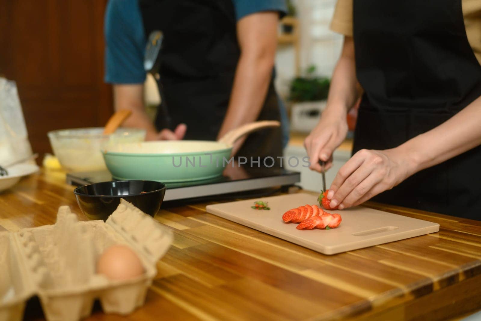Happy young couple preparing ingredients for breakfast at home.