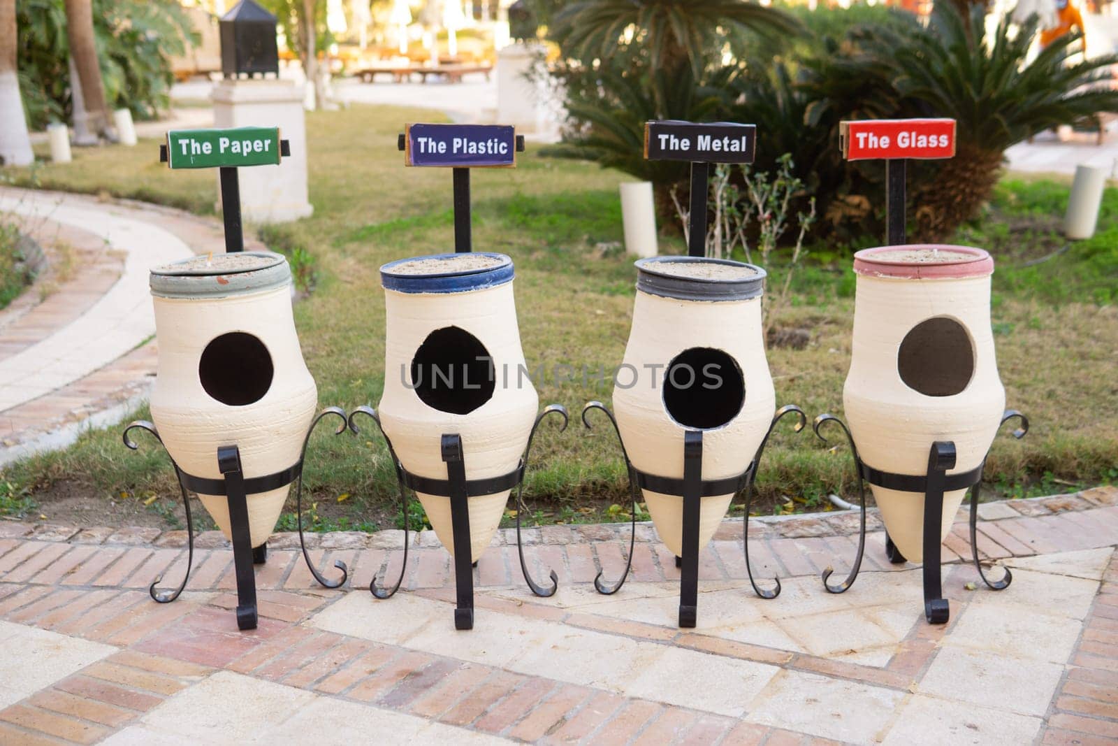 White ceramic outdoor recycling bins specifically for sorting paper plastic metal glass. Environmental waste management concept for public areas and hotels seeking sustainability