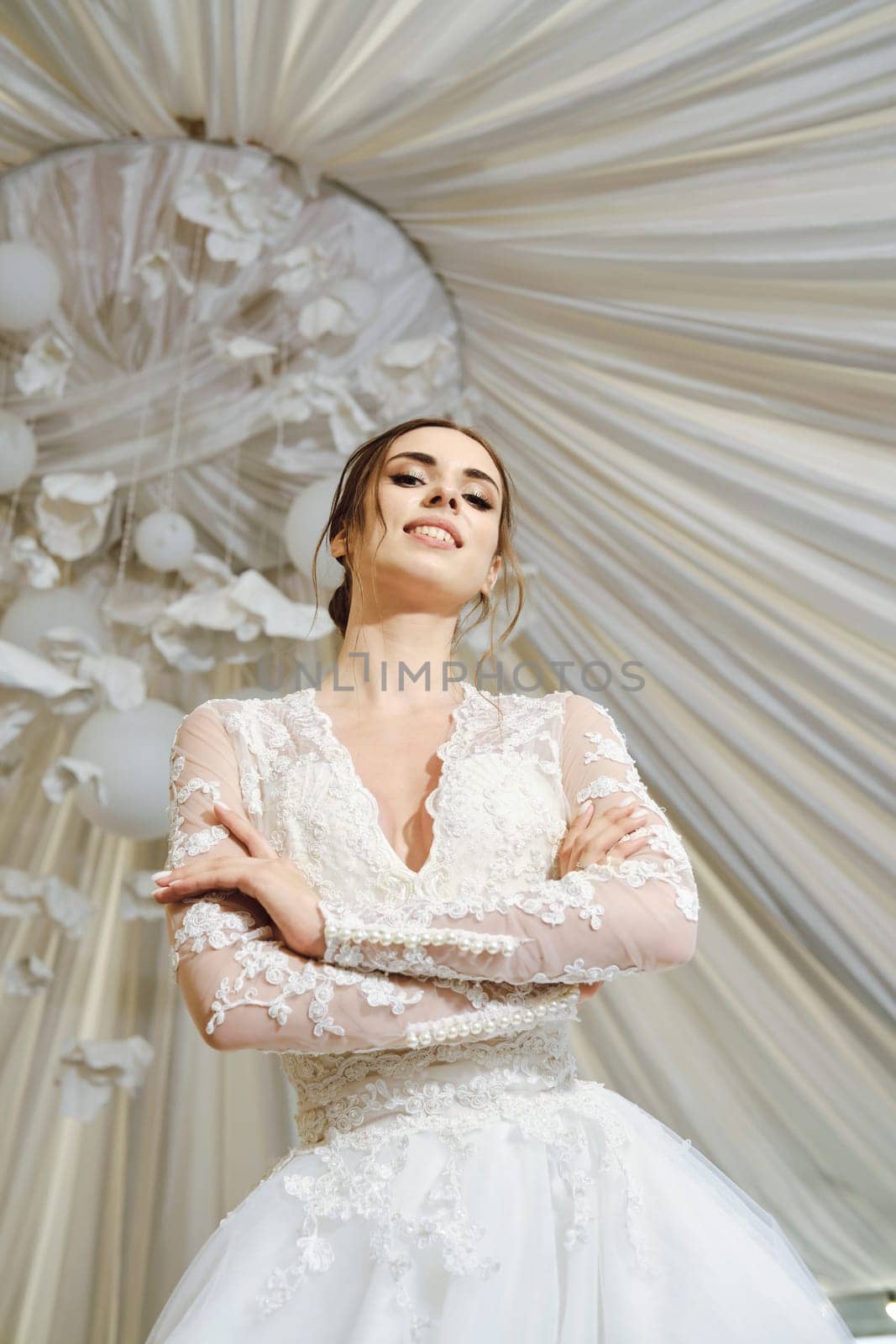 Beautiful bride posing with folded arms, low angle view