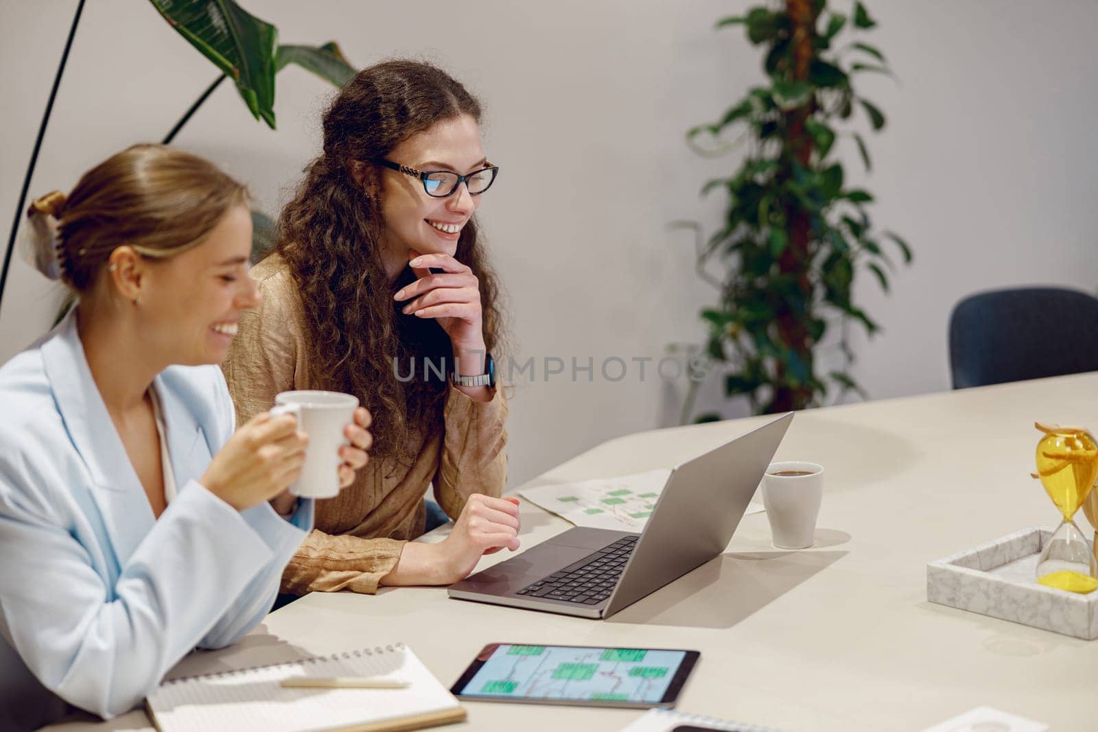 Two skilled professionals hold a productive meeting using advanced technology in a stylish workspace