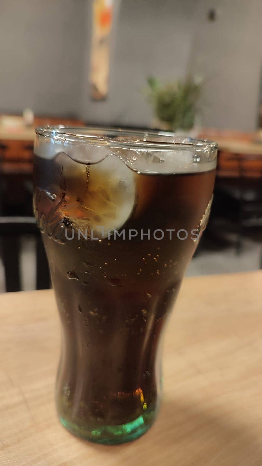 October 22 2024 Hradec Kralove, Czech Republic Europe, Kralov region, Kralovehradecky kraj, Glass cola ice cubes objects drink water table restaurant near . High quality photo
