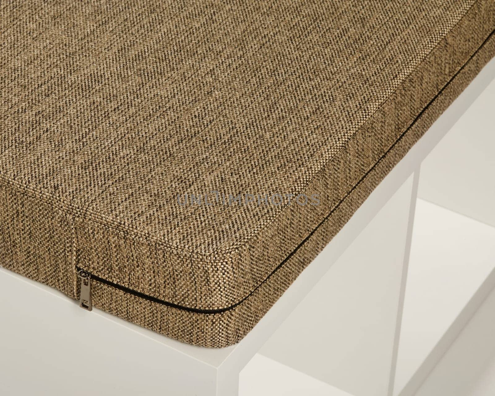 Removable beige fabric cushion cover with zipper on a modern white bench, perfect for adding comfort and style
