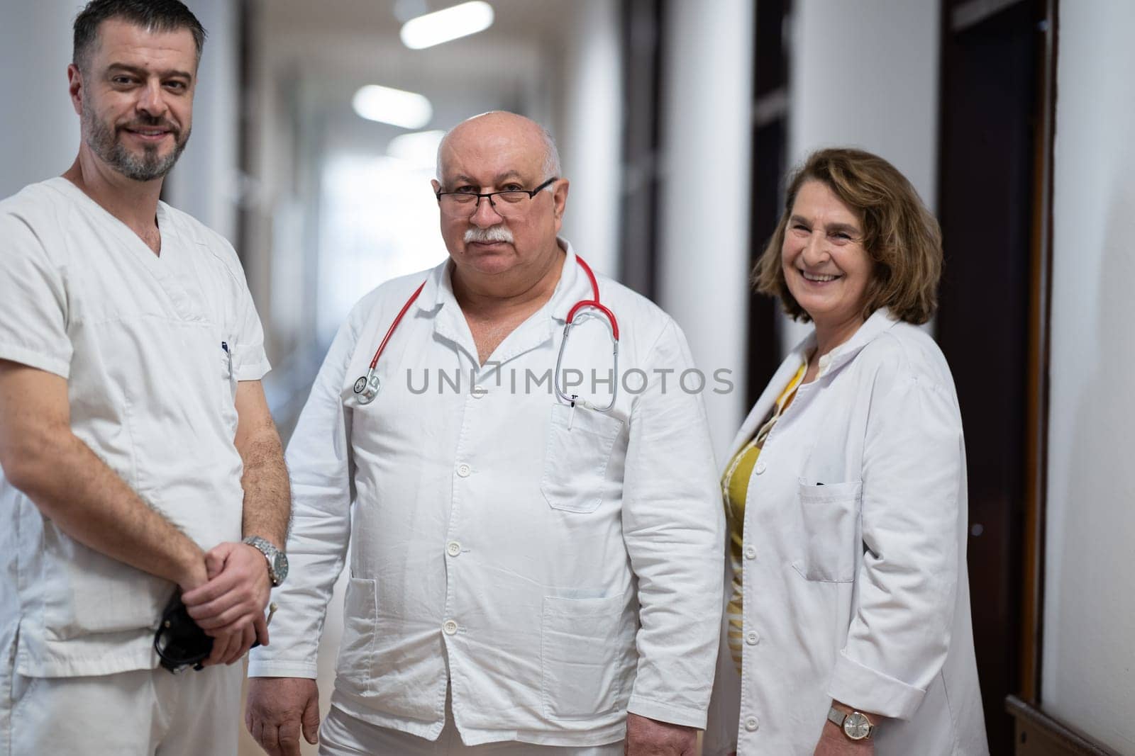 A team of experienced doctors standing in the hospital hallway, weary but dedicated after a long day of caring for patients