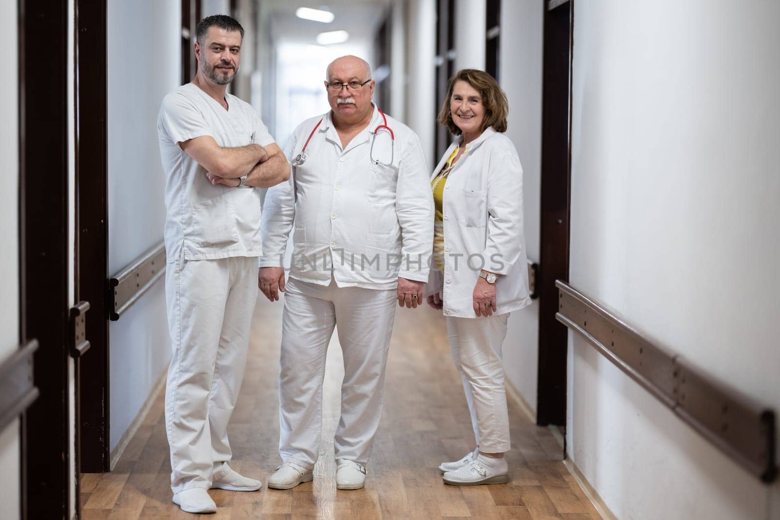 A team of experienced doctors standing in the hospital hallway, weary but dedicated after a long day of caring for patients