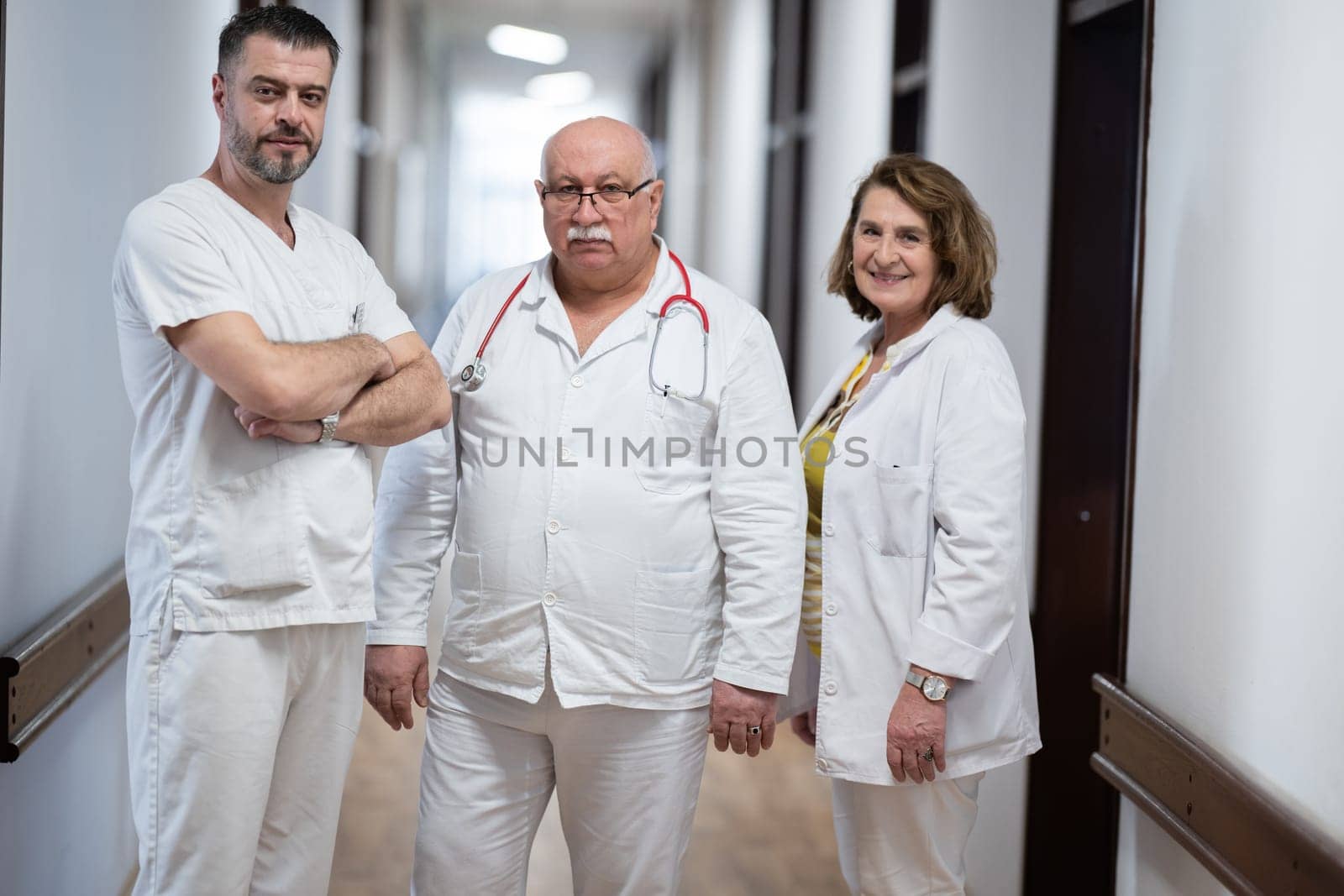 A team of experienced doctors standing in the hospital hallway, weary but dedicated after a long day of caring for patients