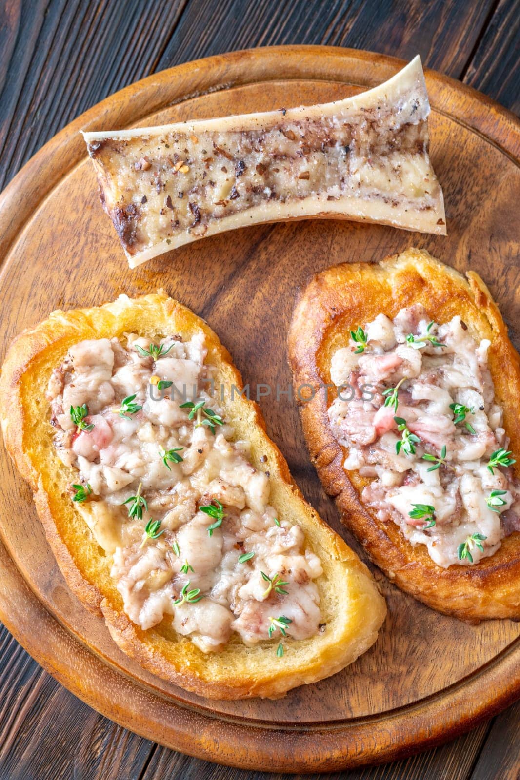 Herb-topped marrow melts into toasted bread, offering bold and buttery rustic indulgence