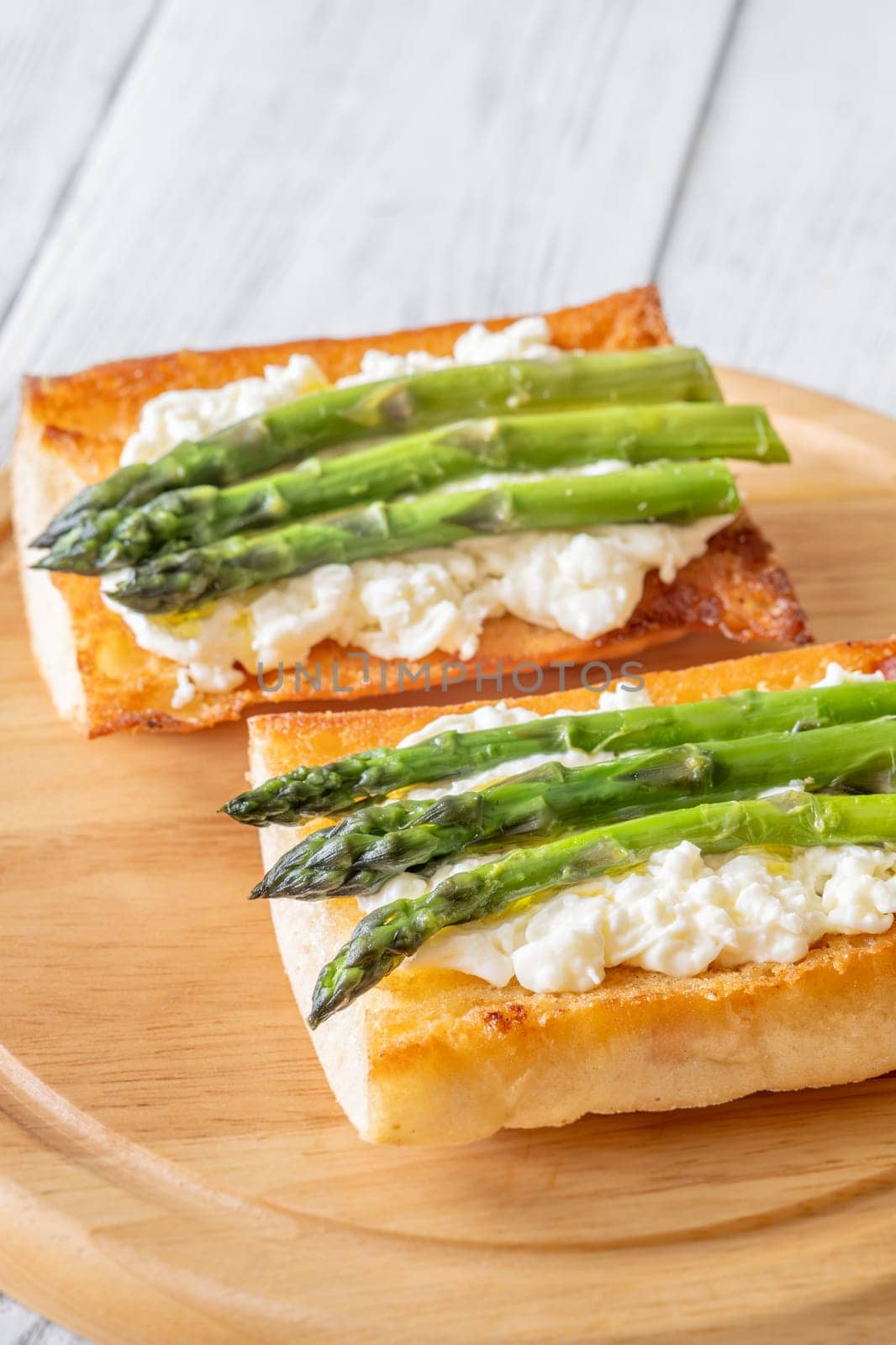 Toasted ciabatta holds creamy cheese and asparagus glistening in golden oil