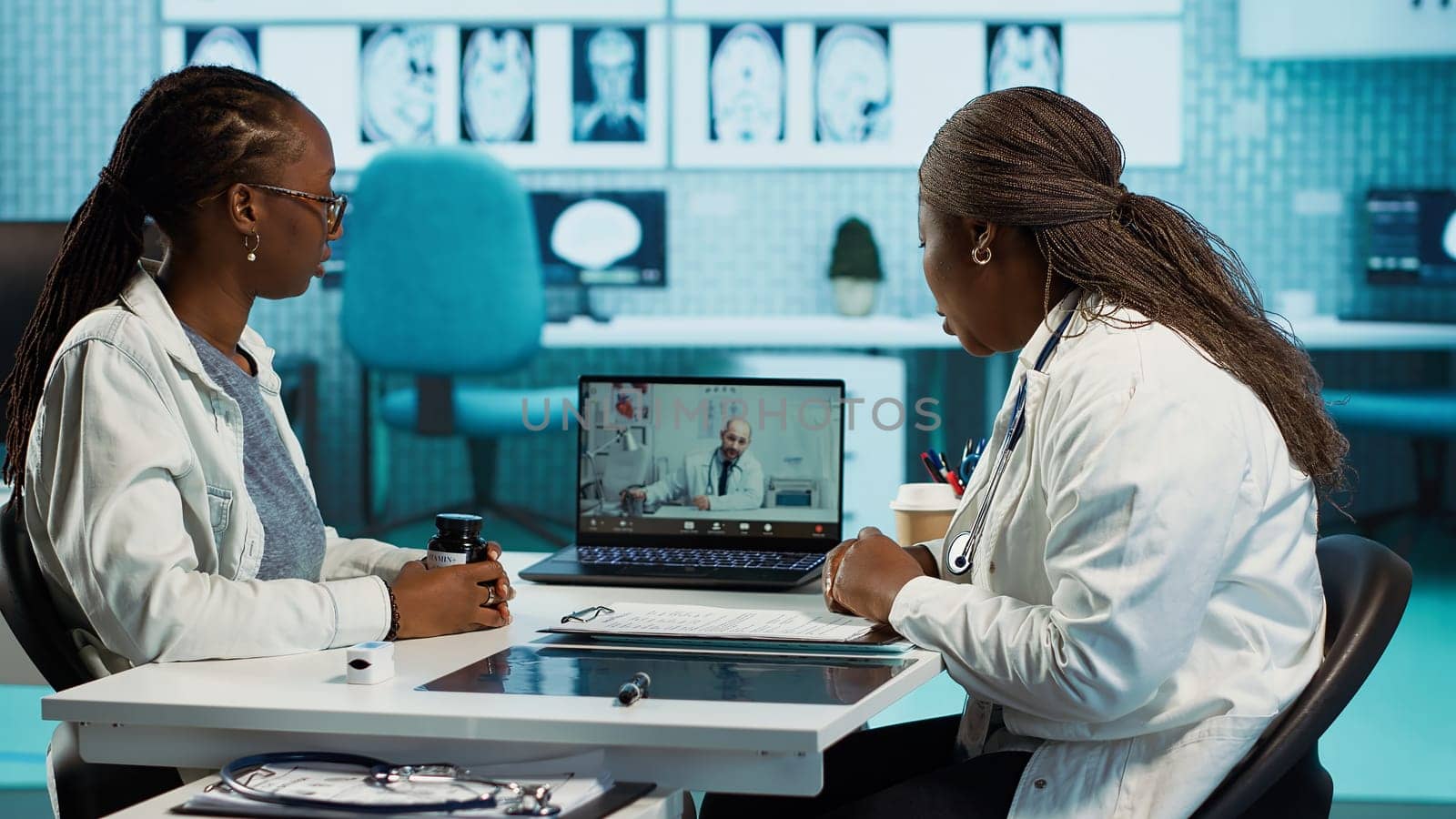 Physician calling the expert practitioner on video conference with a patient, creating a telehealth consultation for a second opinion. Medical staff using high tech equipment at clinic. Camera A.